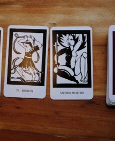 3 tarot cards face-up and the rest of the deck in a pile on a wooden background